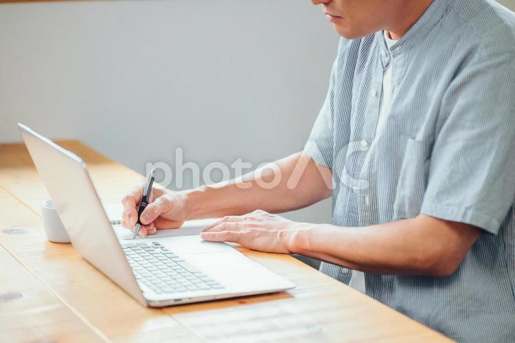 パソコンを使う男性（書く） 勉強,書く,メモの写真素材