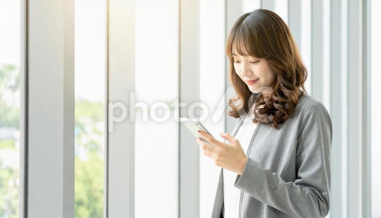スマホを確認するビジネス女性 ビジネスマン,会社員,社会人の写真素材