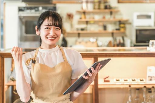 タブレットで注文を確認するカフェスタッフ タブレットで注文を確認するカフェスタッフ カフェ,ウェイトレス,エプロンの写真素材