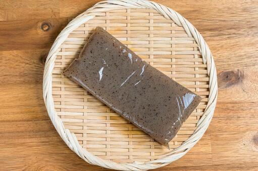 竹ざるにのせたこんにゃく こんにゃく,板,木目背景の写真素材