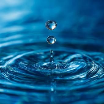 鮮やかな青い水に落ちる水滴の瞬間 鮮やかな青い水に落ちる水滴の瞬間の写真