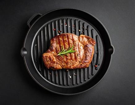 鉄板にのったステーキ肉 鉄板にのったステーキ肉の写真