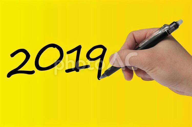 2019年の抱負を書き込むビジネスマンの手-黄色背景 ビジネス,手,男性の写真素材