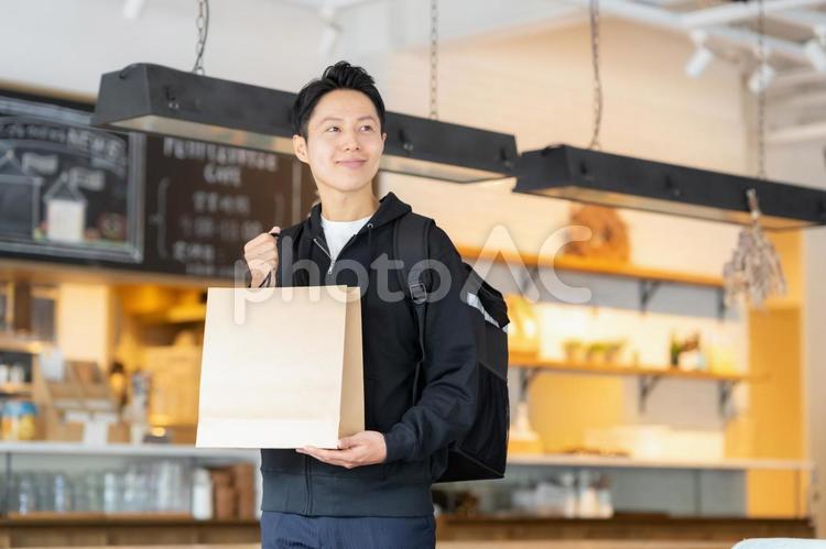 フードデリバリーをする配達員の男性 カフェ,テイクアウト,デリバリーの写真素材