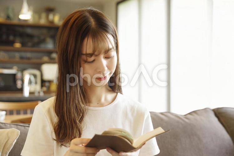 ソファに座って読書をする女性 読書,リラックス,集中の写真素材