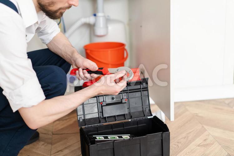 しゃがんで工具を触る人の手元 工具,持つ,手元の写真素材