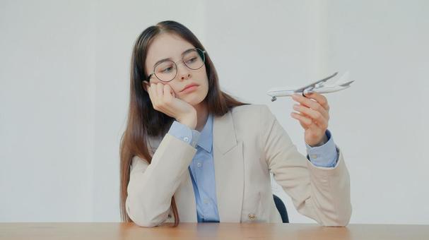 飛行機の模型をもって頬杖をつく女性 事務職,接客業,アドバイザーの写真素材