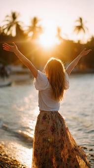 海を背景に輝く女性 海を背景に輝く女性の写真