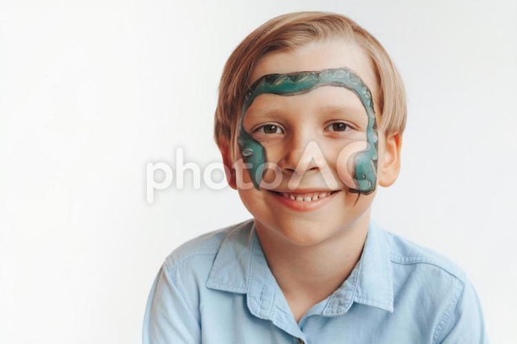 ヘビのフェイスペイントをした笑っている男の子 男の子,フェイスペイント,笑顔の写真素材