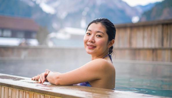 温泉につかってリラックスする若い女性 温泉につかってリラックスする若い女性の写真