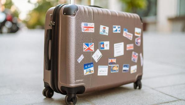 ステッカーをたくさん貼ったスーツケースの写真