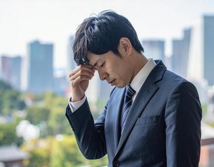悩むビジネスマン 悩むビジネスマンの写真