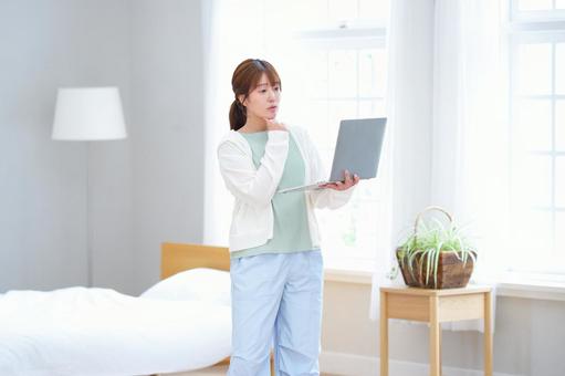 パソコンを持ち悩む女性 女性,ノートパソコン,持つの写真素材