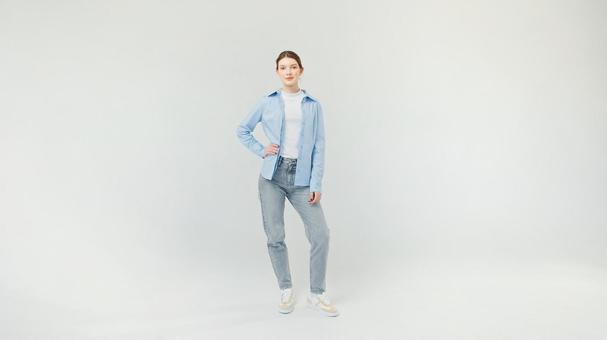 腰に手を当てポーズする青いシャツの女性 腰に手を当てポーズする青いシャツの女性の写真