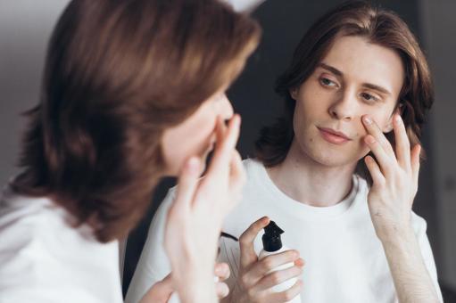 鏡を見ながら乳液を塗っている男性 男性,外国人,欧米人の写真素材