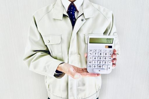 電卓を持つ作業着姿の男性ビジネスマン 料金,提示,プランの写真素材