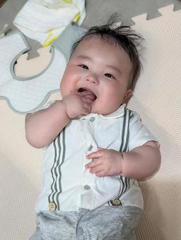 指を口に入れて笑う赤ちゃん 指を口に入れて笑う赤ちゃん 赤ちゃん,ベビー,0歳の写真素材