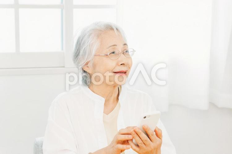 スマホを使う高齢者女性（笑顔） スマホ,高齢者,携帯電話の写真素材