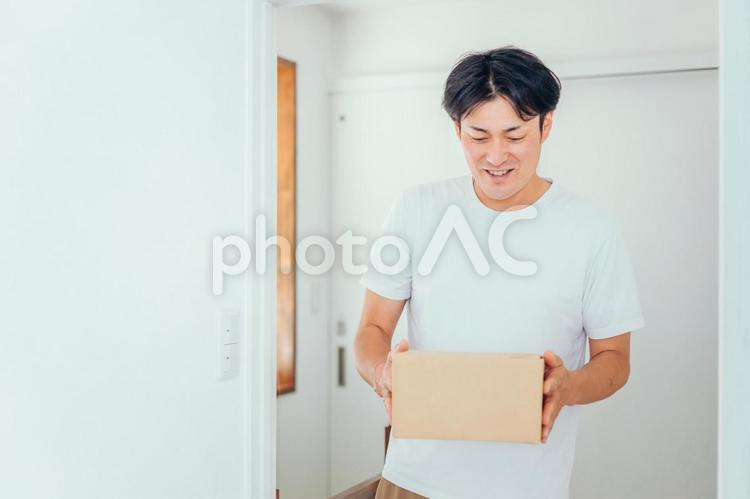 段ボールを運ぶ男性（笑顔） 通販,ネットショッピング,ダンボールの写真素材