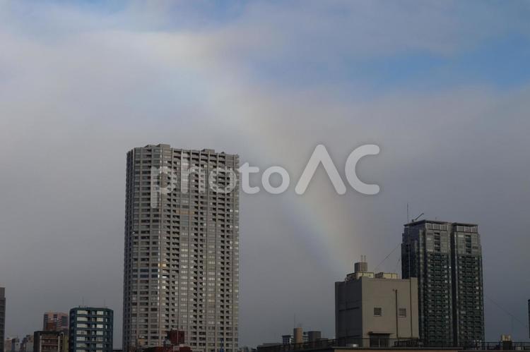 高層ビルの街並みと虹と雲の多い青空の風景 高層ビル,街並み,虹jの写真素材