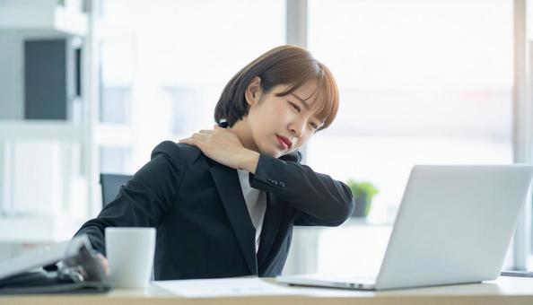 デスクワークで肩こりに悩むビジネスマン デスクワークで肩こりに悩むビジネスマンの写真