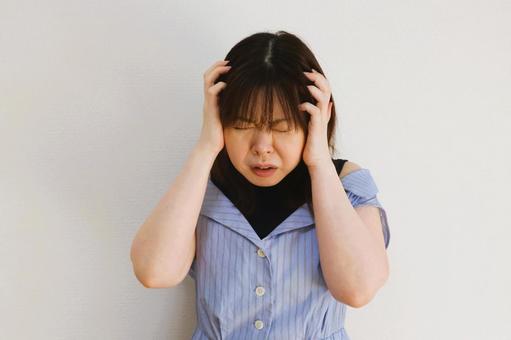 頭を抱える女性 頭を抱える女性の写真