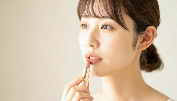 リップを塗る女性 リップを塗る女性の写真