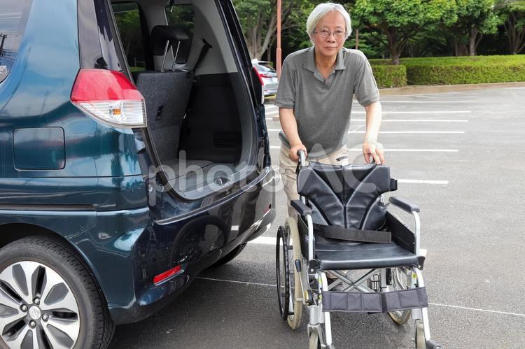 車イスを運ぶシニア 車いす,介護,シニアの写真素材