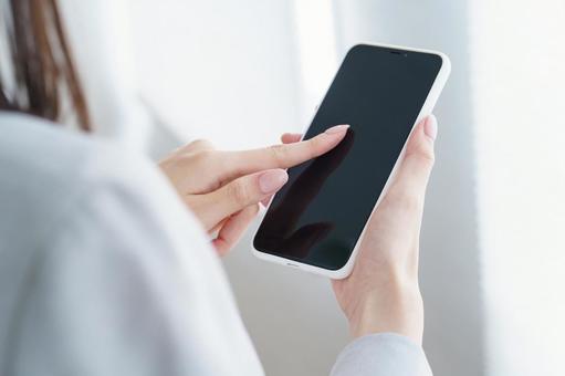 スマートフォンを操作するビジネスウーマン スマートフォンを操作するビジネスウーマン 女性,スマホ,ビジネスの写真素材