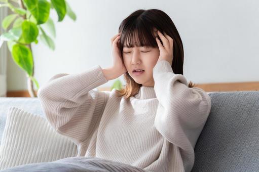 頭を押さえて悩む女性 女性,頭痛,つらいの写真素材