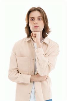 拳を顎に当てポーズする男性 拳を顎に当てポーズする男性の写真