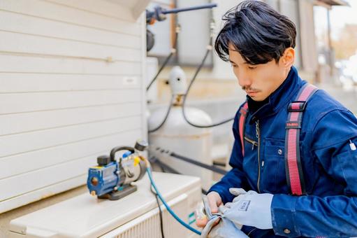 室外機の設置をする電気工事士 室外機の設置をする電気工事士 工事,電気,仕事の写真素材