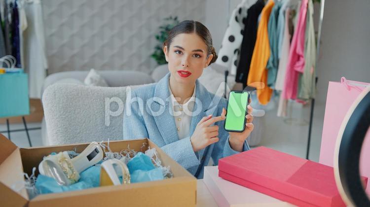 携帯を指をさして説明する女性 女性,人物,スマートフォンの写真素材
