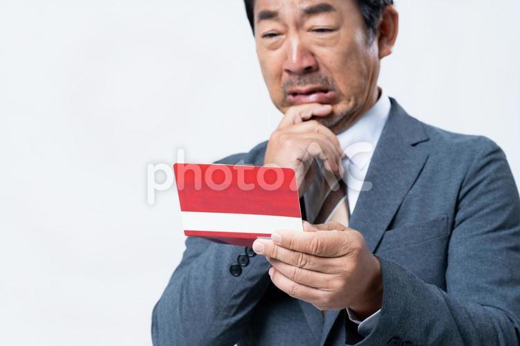 悩むミドルのビジネスマン 悩む,通帳,ビジネスマンの写真素材