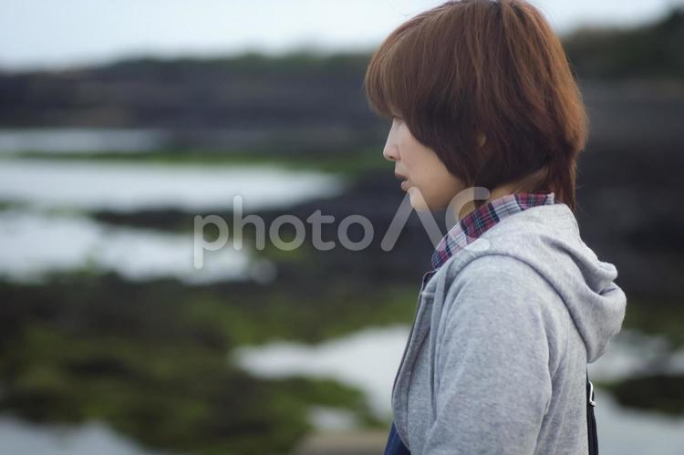 ＜人物＞海辺を孤独に散歩する女性 女性,悩む,海の写真素材