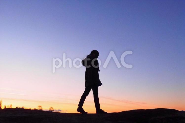 夕陽に染まる女性のシルエット シルエット,女性,夕暮れの写真素材