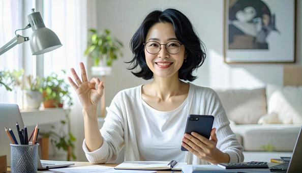 家計がうまくいきスマホ片手に微笑む女性 家計がうまくいきスマホ片手に微笑む女性の写真