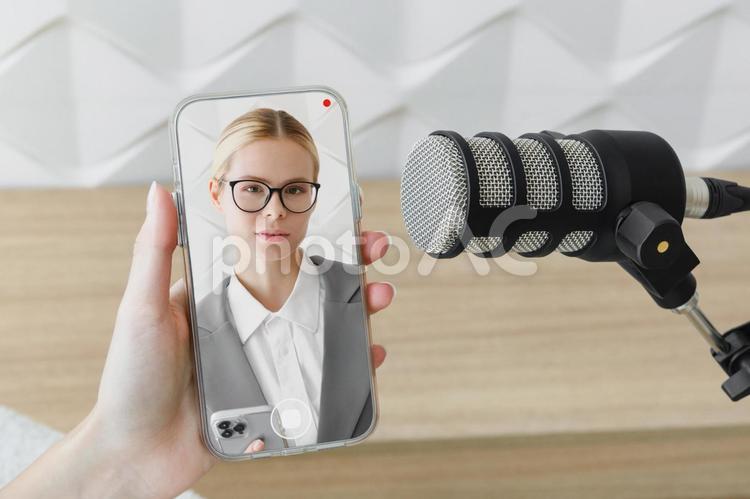 スマホ画面に映る女性とマイク 女性,スマートフォン,持つの写真素材
