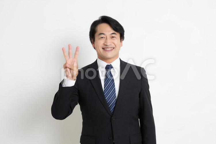 笑顔で指を3本立てている中年のサラリーマン男性 中年,上司,会社員の写真素材