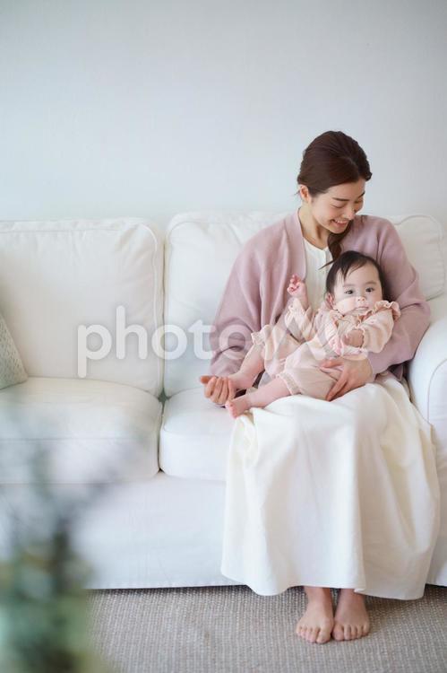 ソファで抱っこするスカートの女性 母子,赤ちゃん,見つめるの写真素材