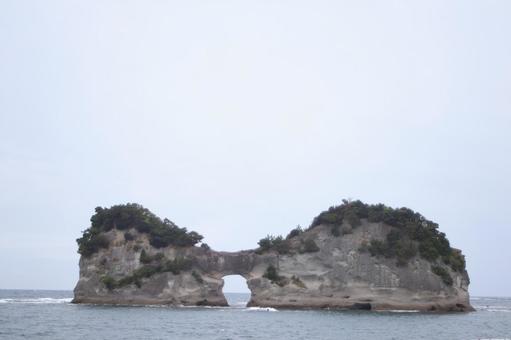 曇天の中凛々しく立つ円月島 曇天の中凛々しく立つ円月島の写真