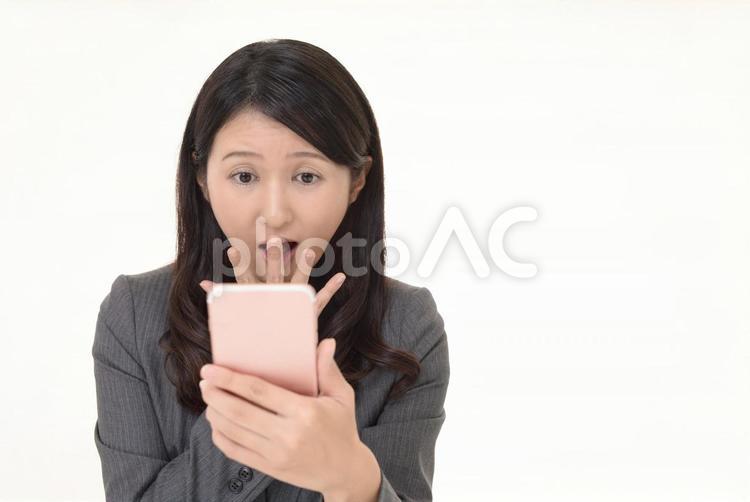 スマホの画面を見て驚く女性 女性,ビジネスウーマン,スマートフォンの写真素材