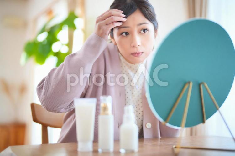 鏡を見ながら白髪を気にする女性 女性,主婦,鏡の写真素材