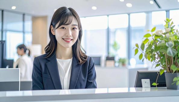 笑顔で対応する女性の受付嬢 笑顔で対応する女性の受付嬢の写真