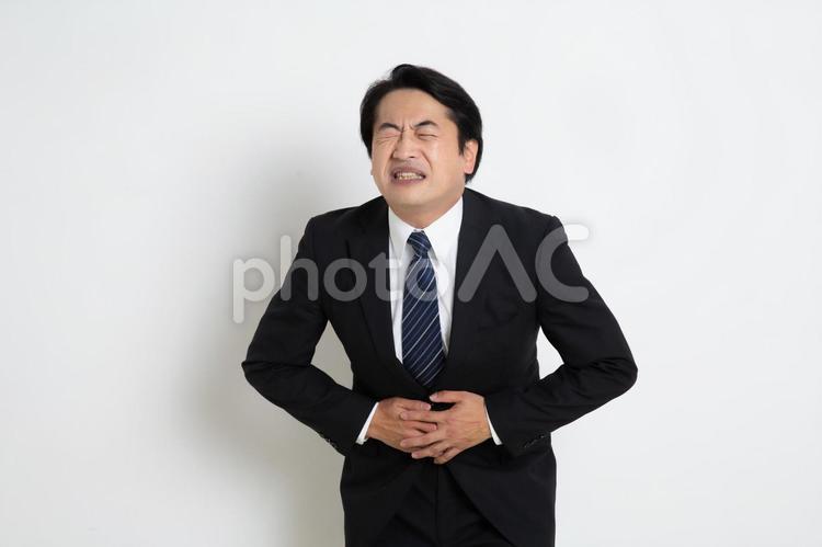 ストレスでお腹が痛くなった中年のサラリーマン男性 中年,上司,会社員の写真素材