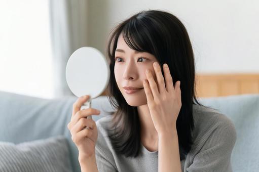 鏡で肌をチェックする女性 鏡で肌をチェックする女性 女性,美容,健康の写真素材