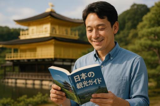 ガイドブックを見る男性旅行者 ガイドブックを見る男性旅行者の写真