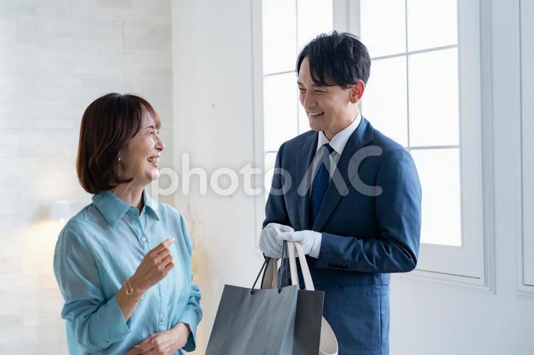 買い物の袋を持つスーツの男性と女性客 ショッピング,コンシェルジュ,ブランドの写真素材