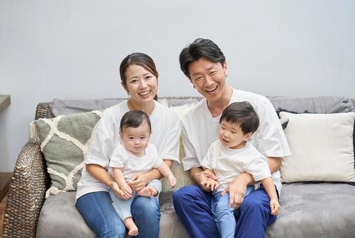 部屋のソファーでくつろぐ親子4人 部屋のソファーでくつろぐ親子4人 家族,育児,ファミリーの写真素材