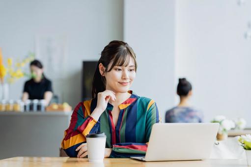 カフェで仕事をするフリーランスの女性 カフェで仕事をするフリーランスの女性 テレワーク,ノマド,フリーランスの写真素材